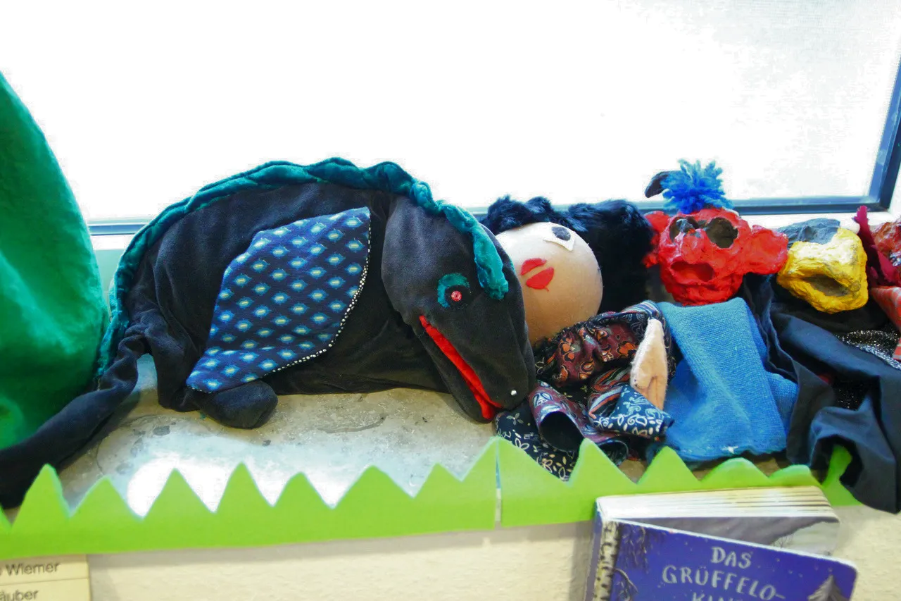 Handpuppen auf der Fensterbank, daneben das Bilderbuch „Der Grüffelo“.